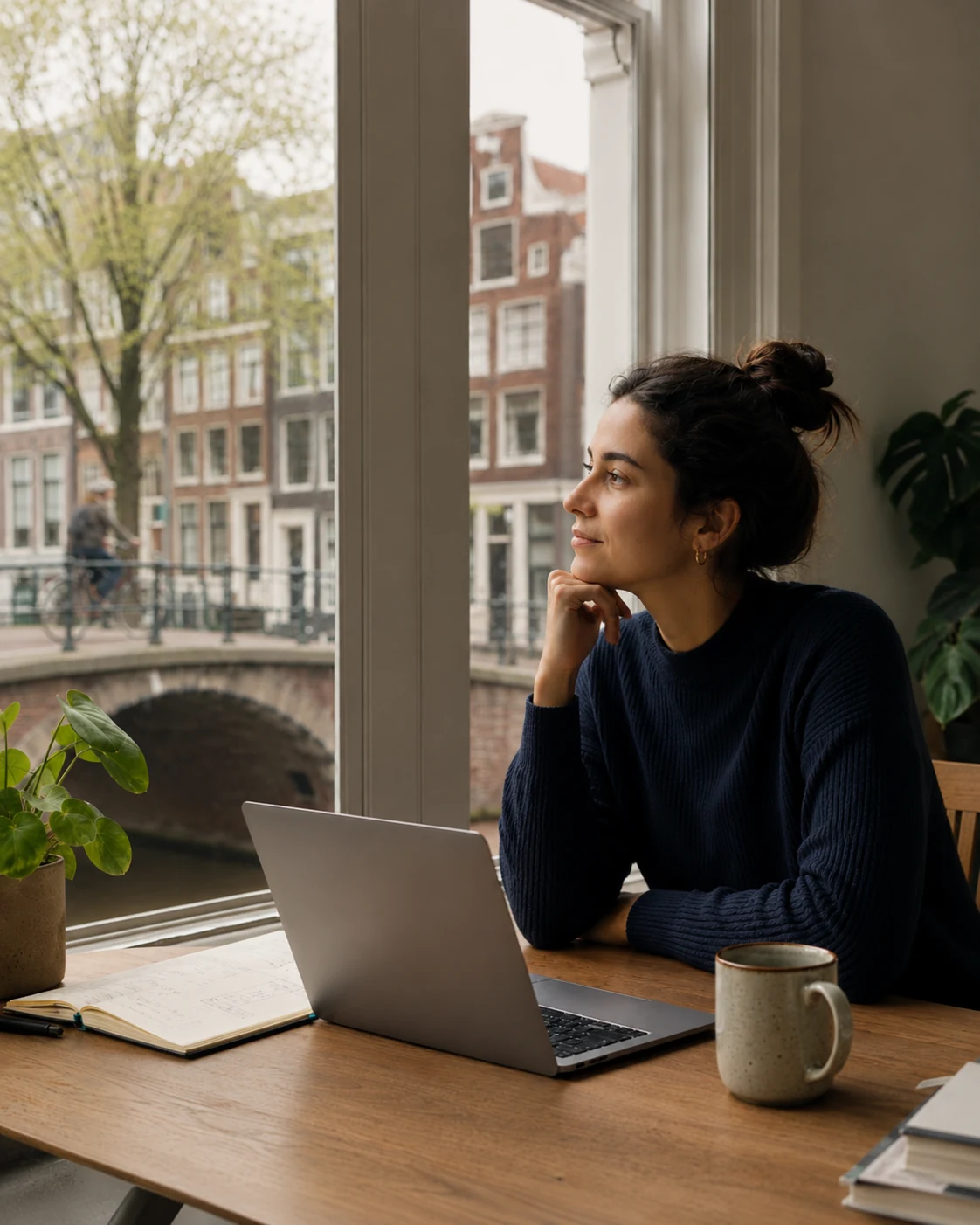 Internationale professional in gedachten bij een werkplek aan een gracht in Nederland.